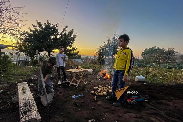 Дети Розы из числа вынужденных переселенцев из Карабаха пекут картошку в Мартуни - Sputnik Армения
