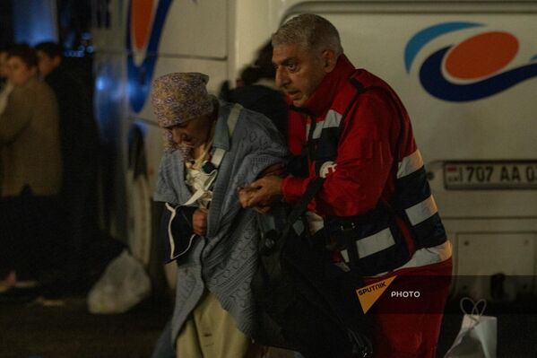 Տղամարդն օգնում է գաղթի ճամփան անցած ծեր կնոջը հասնել ընդունման կետ - Sputnik Արմենիա