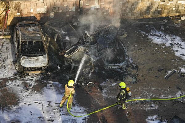 Израильские пожарные тушат автомобили, поврежденные в результате атаки Палестины. - Sputnik Армения