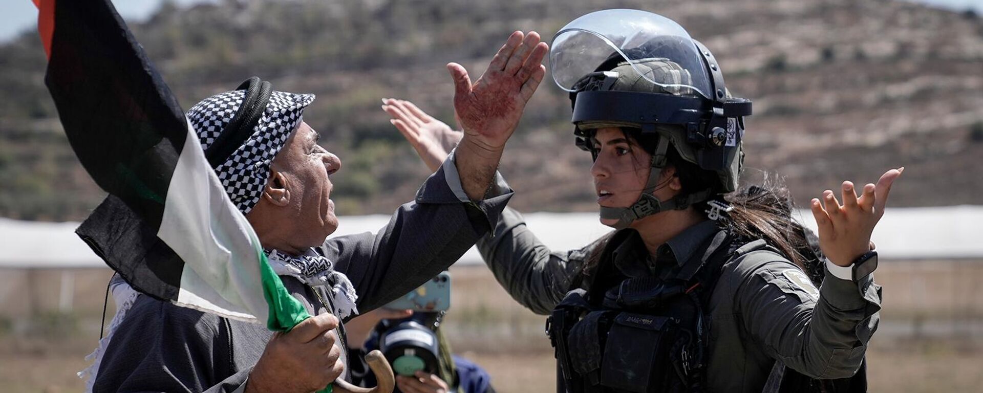 Палестинский протестующий спорит с сотрудницей израильских сил безопасности во время демонстрации против израильских поселений в деревне Карьют (15 сентября 2023). Наблус - Sputnik Армения, 1920, 09.10.2023