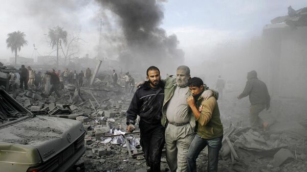 Местные жители помогают раненому палестинцу выбраться из-под завалов после израильского ракетного удара по подконтрольной ХАМАСУ территории Рафах (27 декабря 2008). Сектор Газа - Sputnik Армения