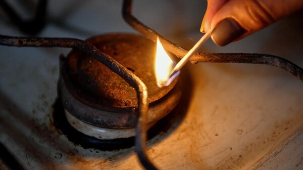 Женщина зажигает конфорку газовой плиты в жилом доме - Sputnik Արմենիա