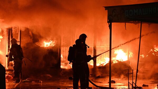 Сотрудники пожарной службы тушат пожар на вещевом рынке Темерник в Ростове-на-Дону - Sputnik Армения