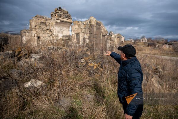 Житель Ширакамута Гагик Наслян показывает руины церкви Св. Аствастатин, разрушенной во время землетрясения - Sputnik Армения