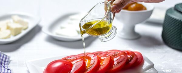 Женщина поливает помидоры оливковым маслом Женщина поливает помидоры оливковым маслом - Sputnik Армения