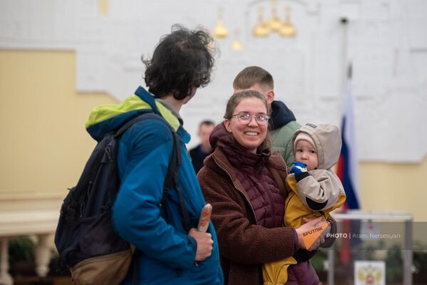 Երիտասարդ ընտանիքը, ժպիտը դեմքներին, սպասում է քվեարկության հերթին - Sputnik Արմենիա