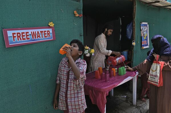 Հնդկաստանի Հայդարաբադ քաղաքում ամառային շոգ օրը կամավորը խմելու ջուր է բաժանում ավտոբուսի կանգառի մոտ - Sputnik Արմենիա