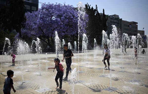 Люди охлаждаются у фонтана в Мехико, где зафиксирована рекордно высокая температура. - Sputnik Армения