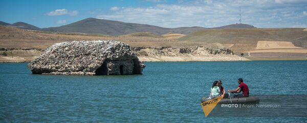 Туристы плывут на лодке у церкви Сурб Рипсиме в водоеме у села Толорс, Сюник Туристы плывут на лодке у церкви Сурб Рипсиме в водоеме у села Толорс, Сюник - Sputnik Армения