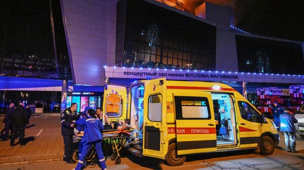 Скорая помощь с ранеными у концертного зала Крокус Сити Холл, где произошла стрельба (22 марта 2024). Москва - Sputnik Армения