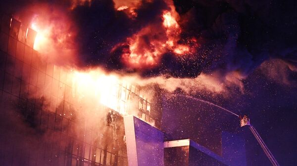 Пожарные тушат горящую крышу концертного зала Крокус Сити Холл, где произошла стрельба (22 марта 2024). Москва - Sputnik Армения