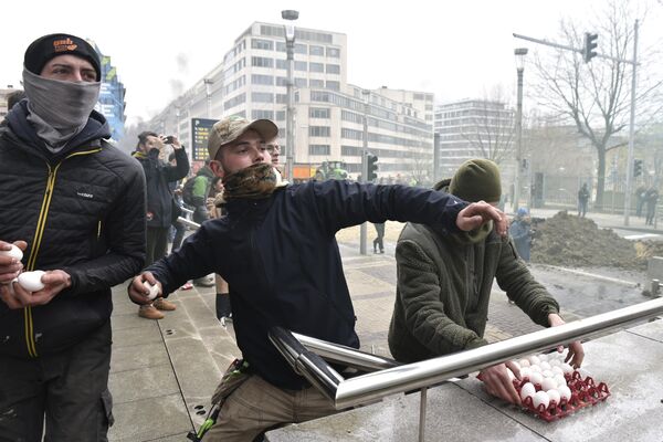 Протестующие бросают яйца в полицию во время демонстрации возле здания Европейского совета в Брюсселе, Бельгия. - Sputnik Армения