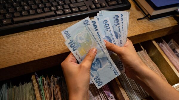 Работник пункта обмена валюты пересчитывает банкноты в турецких лирах (6 августа 2020). Стамбул - Sputnik Армения