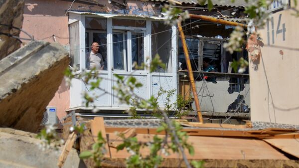 Люди на балконах многоквартирного дома в городе Токмак, частично разрушенного в результате обстрела ВСУ (13 апреля 2024).  Запорожская область - Sputnik Армения