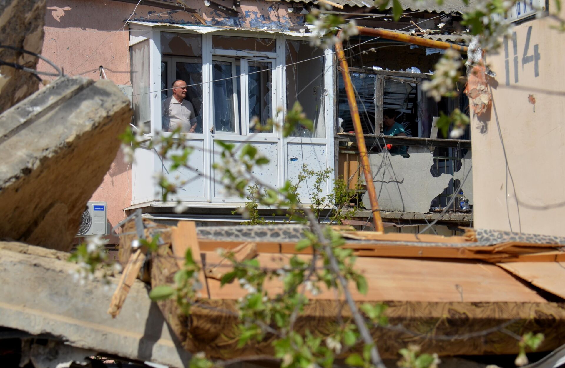 Люди на балконах многоквартирного дома в городе Токмак, частично разрушенного в результате обстрела ВСУ (13 апреля 2024).  Запорожская область - Sputnik Արմենիա, 1920, 13.04.2024