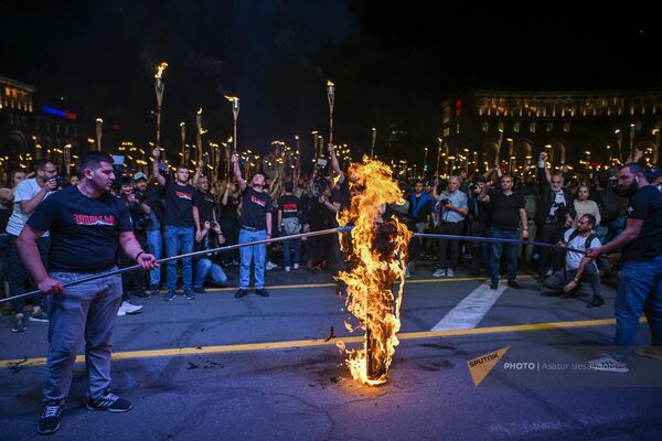 Участники факельного шествия сжигают флаги Турции и Азербайджана на площади Республики перед началом традиционного шествия (23 апреля 2024). Еревaн - Sputnik Армения