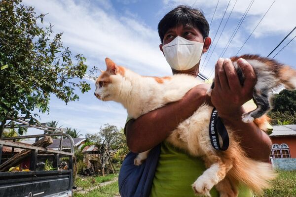 Волонтер спасает кошек из заброшенных домов после извержения вулкана Руанг на острове Тагуланданг в Ситаро - Sputnik Армения