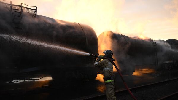 Пожарный во время тушения пожара на территории железнодорожной станции в Шахтерске - Sputnik Армения