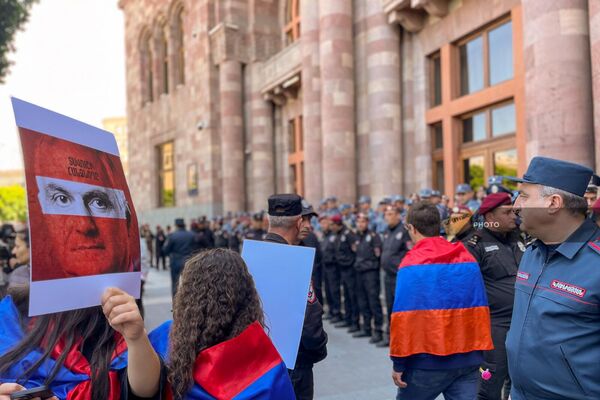 Активистка держит плакат с изображением вице-премьера Мгера Григоряна перед зданием Дома правительства на площади Республики (16 мая 2024). Еревaн - Sputnik Армения