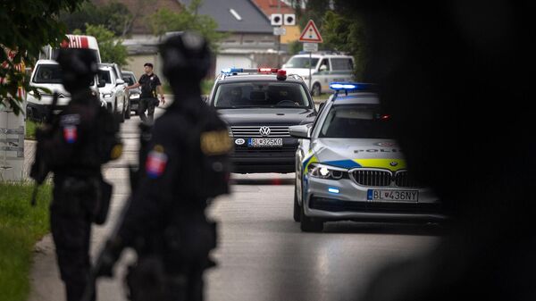 Полиция охраняет территорию рядом с судом, куда конвой доставляет подозреваемого в покушении на премьер-министра Словакии (18 мая 2024). Безинок - Sputnik Армения