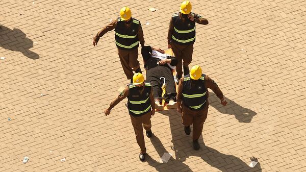 Спасатели выносят на носилках пострадавшего от палящего зноя мужчину во время прибытия мусульманских паломников в Мину (16 июня 2024). Саудовская Аравия - Sputnik Армения