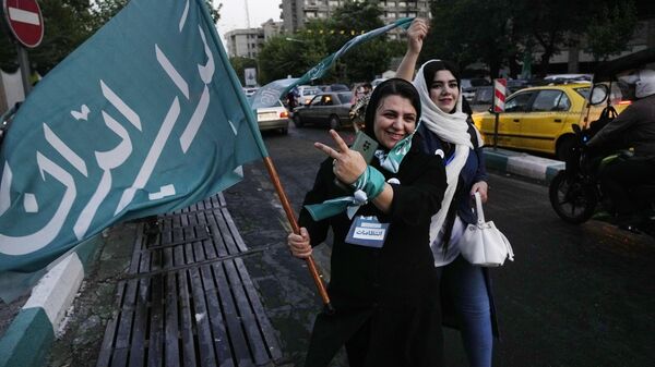 Իրանի նախագահական ընտրություններում ռեֆորմատոր թեկնածու Մասուդ Պեզեշկիանի աջակցի ձեռքին դրոշ է, որի վրա պարսկերեն գրված է «հանուն Իրանի» - Sputnik Արմենիա