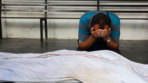 Мужчина оплакивает тело палестинского врача после ночного израильского авиаудара по клинике ад-Дарадж (24 июня 2024). Газа - Sputnik Армения