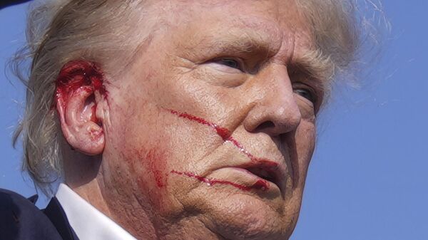 Кандидат в президенты США от Республиканской партии Дональд Трамп с окровавленным лицом после покушения на предвыборном мероприятии в Батлере (13 июля 2024). Пенсильвания - Sputnik Армения