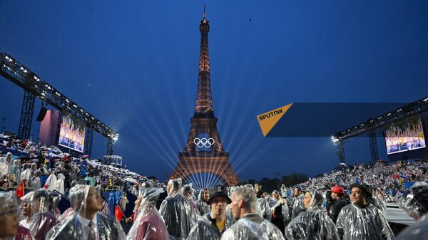 Жители и гости французской столицы прикрываются от дождя на церемонии открытия летних Олимпийских игр 2024 года (26 июля 2024). Париж - Sputnik Армения