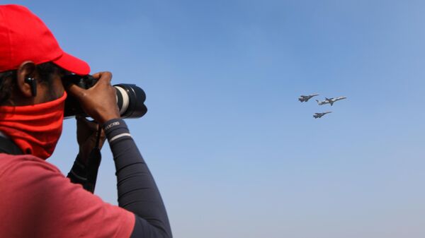 Фотограф снимает полет многоцелевых истребителей Су-30 и самолета дальнего радиолокационного обнаружения и управления ERJ-145I NETRA ВВС Индии на Aero India 2025  - Sputnik Армения