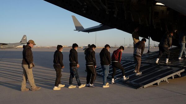 Сотрудники таможенной и пограничной служб США сопровождают нелегальных иммигрантов на борт самолета C-17 Globemaster III (23 января 2025). Форт-Блисс - Sputnik Армения