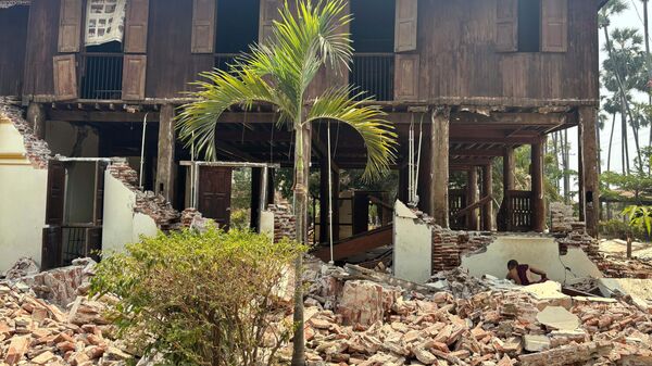 Буддийский монах рядом с поврежденным зданием монастырского комплекса после землетрясения в Найпито, Мьянма. - Sputnik Армения