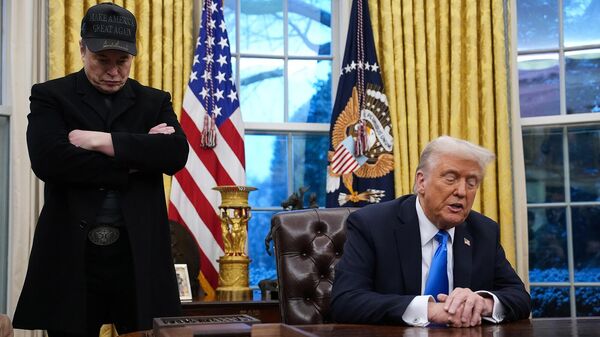Илон Маск стоит рядом с президентом США Дональдом Трампом во время подписания указа в Овальном кабинете Белого дома (11 февраля 2025). Вашингтон - Sputnik Армения