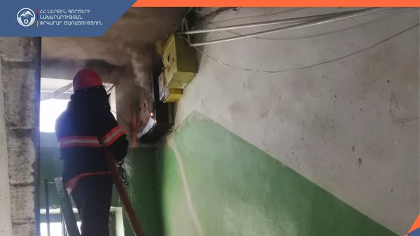 Спасатель на месте задымления в подъезде одного из зданий на улице Григора Лусаворича (16 мая 2025). Ванадзор - Sputnik Армения