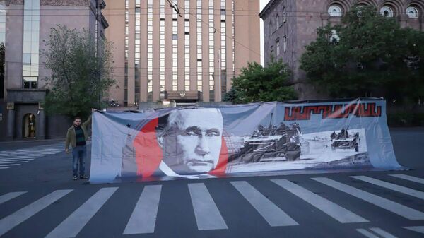 Баннер с портретом Владимира Путина на акции протеста напротив посольства РФ (20 мая 2025). Еревaн - Sputnik Армения