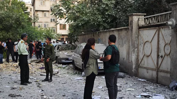 Люди на месте взрывов, нанесенных израильскими авиаударами по Тегерану (13 июня 2025). Иран - Sputnik Армения