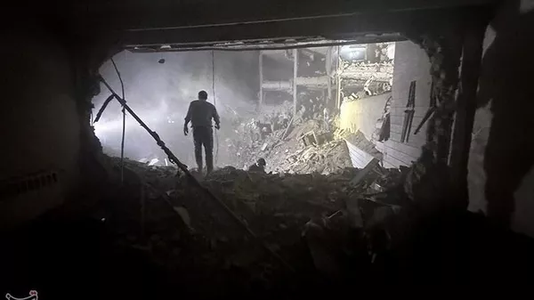 Спасатели на месте взрыва после израильской атаки в районе Нармак (15 июня 2025). Тегеран - Sputnik Армения