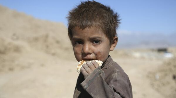 Ребенок ест хлеб на окраине Кабула - Sputnik Армения
