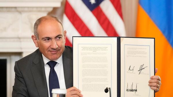 Премьер-министр Армении Никол Пашинян держит в руках подписанное трехстороннее соглашение во время церемонии с президентами США и Азербайджана в Белом доме (8 августа 2025). Вашингтон - Sputnik Армения