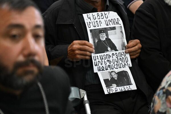 Священник с плакатом в ожидании судебного заседания по делу предстоятеля Ширакской епархии архиепископа Микаэла Аджапахяна - Sputnik Армения