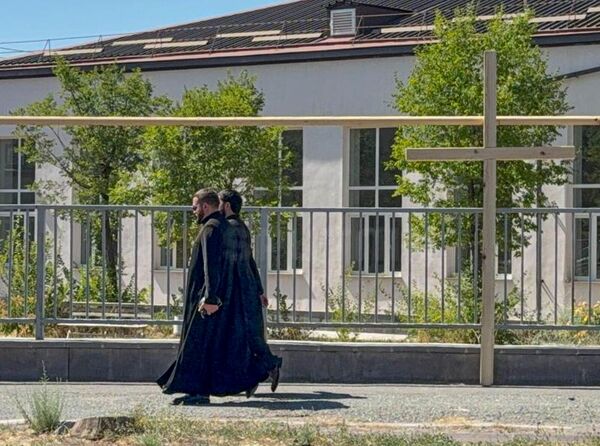 Священники идут мимо креста во время судебного заседания по делу предстоятеля Ширакской епархии архиепископа Микаэла Аджапахяна - Sputnik Армения