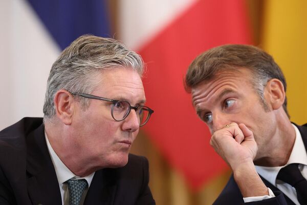 Премьер-министр Великобритании Кир Стармер и президент Франции Эммануэль Макрон беседуют друг с другом во время встречи с президентами США, Украины и европейскими лидерами (18 августа 2025). Вашингтон  - Sputnik Армения