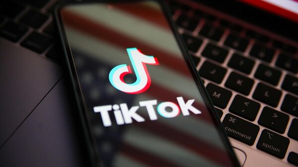 Логотип TikTok на телефоне с отображением флага США - Sputnik Армения