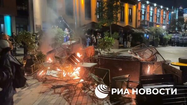 Митингующие в Тбилиси подожгли ограждения, которые они сделали из мебели ресторана для защиты от спецназа - Sputnik Армения