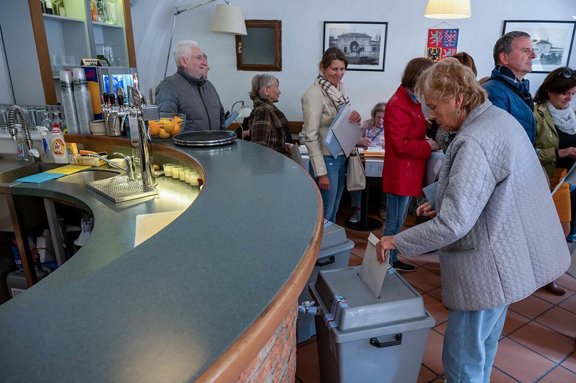 Женщина голосует на избирательном участке, расположенном в местном баре, во время выборов в парламент (3 октября 2025). Чешская Республика - Sputnik Արմենիա, 1920, 05.10.2025