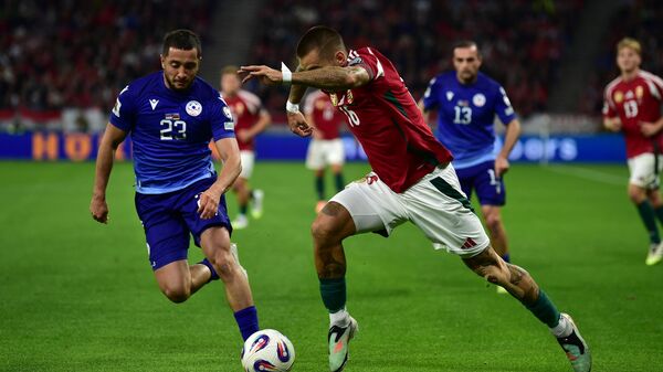 Борьба за мяч между Вааном Бичахчяном и Даниэлем Лукачем из Венгрии во время отборочного матча чемпионата мира по футболу 2026 года между Венгрией и Арменией на арене Пушкаш (11 октября 2025). Будапешт - Sputnik Армения