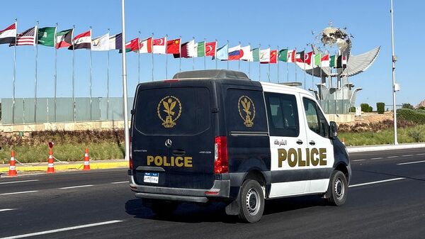 Полицейский автомобиль проезжает мимо флагов стран-участниц саммита, организованного египетским правительством в честь подписания соглашения о прекращении огня между Израилем и ХАМАС (12 октября 2025). Шарм-эль-Шейх - Sputnik Армения