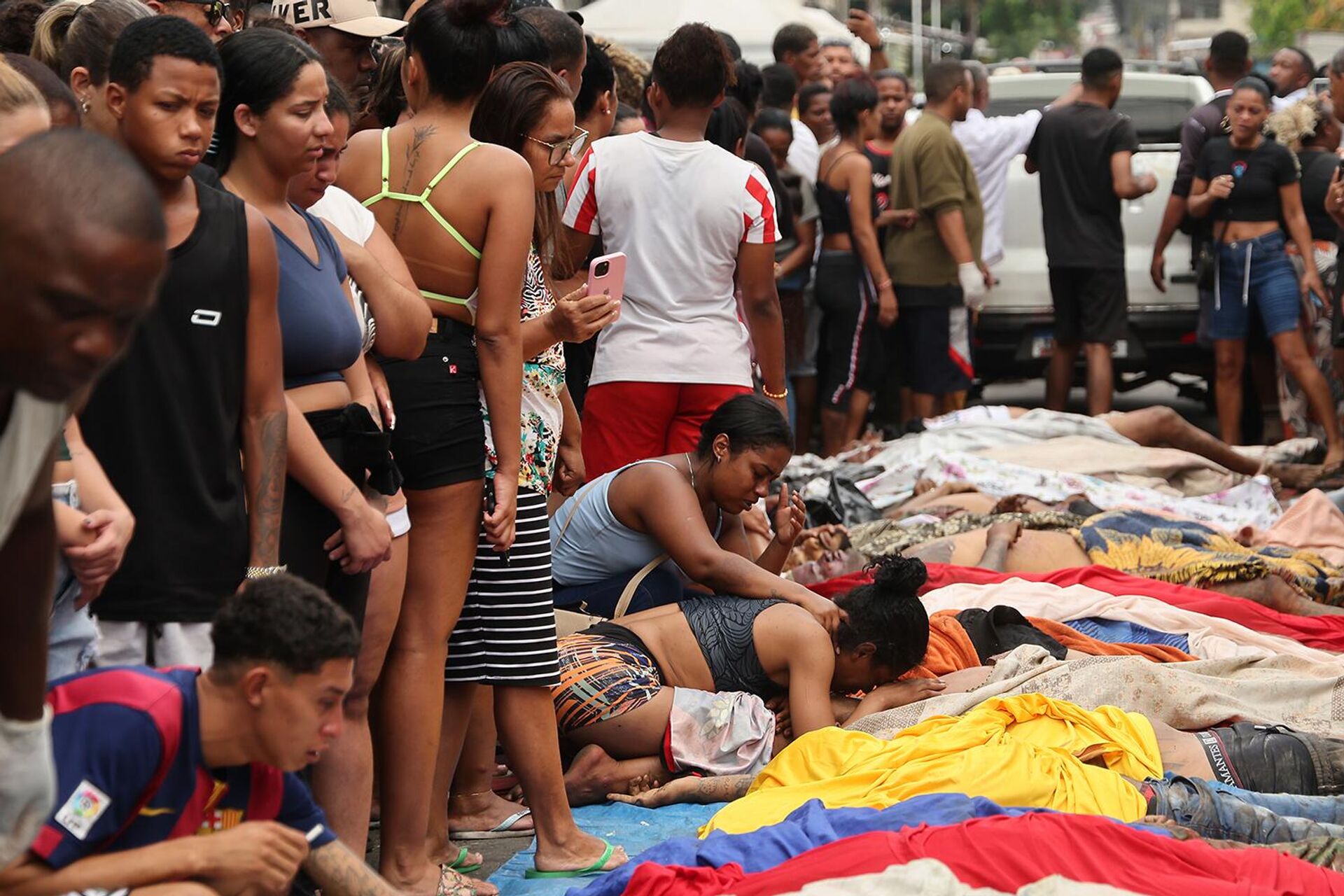 Люди оплакивают тела, найденные на следующий день после масштабной полицейской операции по борьбе с бандами (29 октября 2025). Рио-де-Жанейро - Sputnik Армения, 1920, 29.10.2025