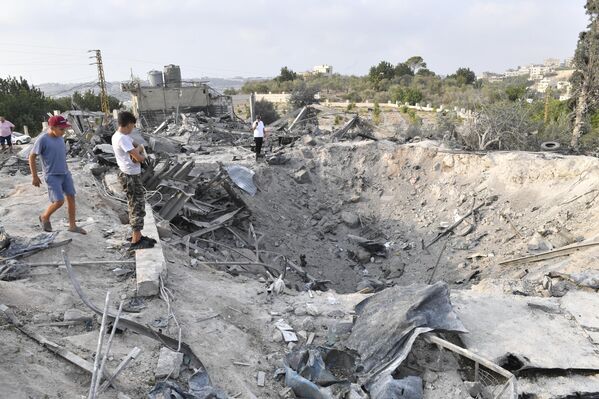 Жители осматривают воронки, оставшиеся после израильских авиаударов в ливанском Тире - Sputnik Армения