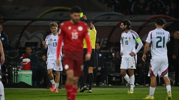 Рефери Жозе Мария Санчес показывает желтую карточку главному тренеру сборной Армении Егише Меликяну во время отборочного матча чемпионата мира по футболу 2026 года между сборными Армении и Венгрии (14 ноября 2025). Еревaн - Sputnik Армения